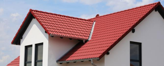 A new, white residential home with a red roof