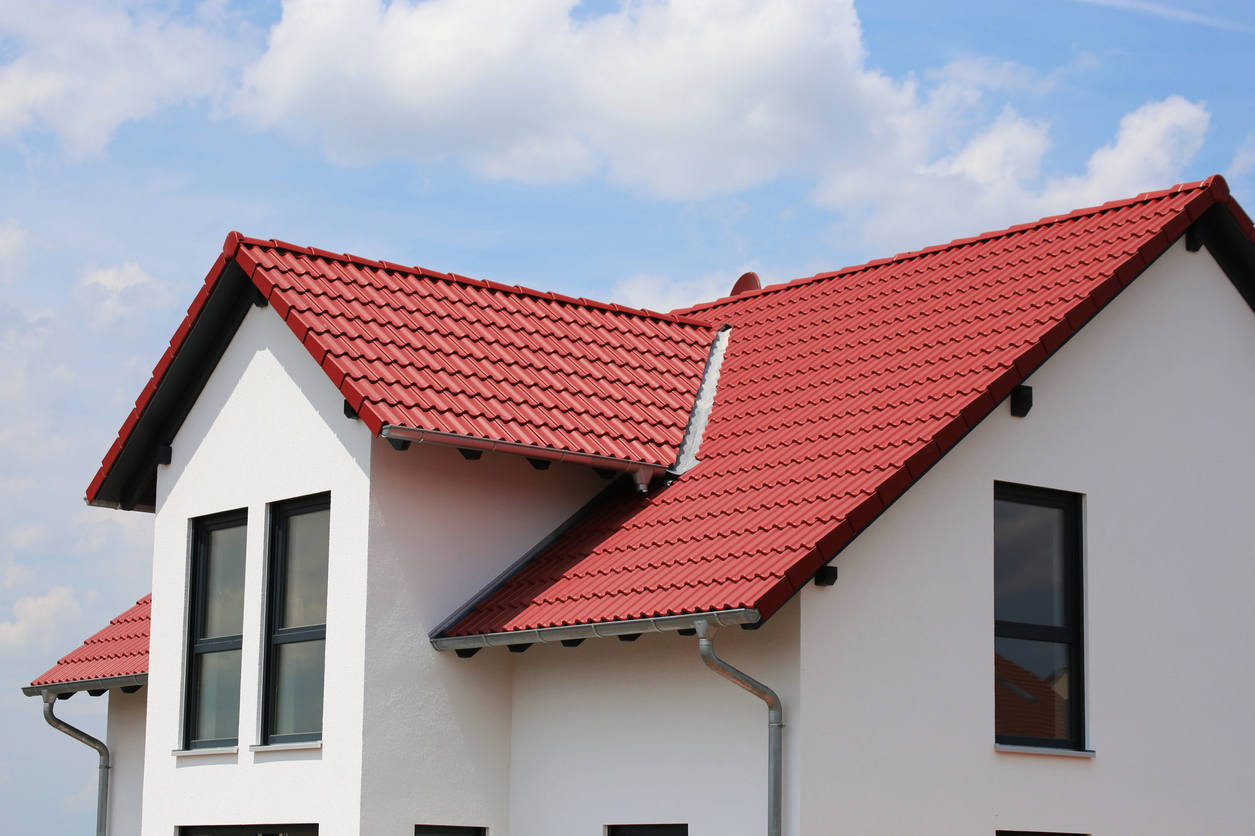 A new, white residential home with a red roof