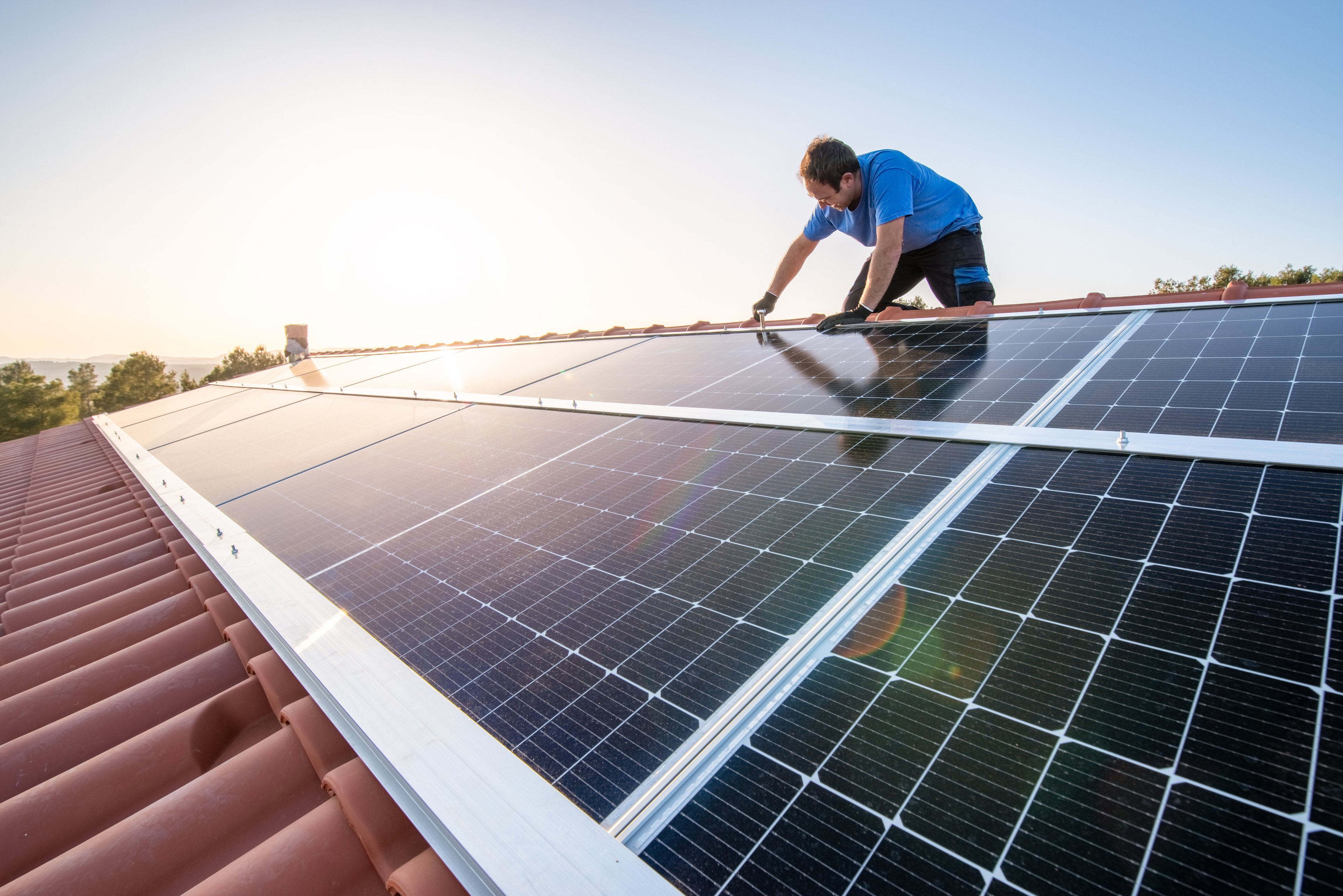 Installing solar panel on roof during the late evening.