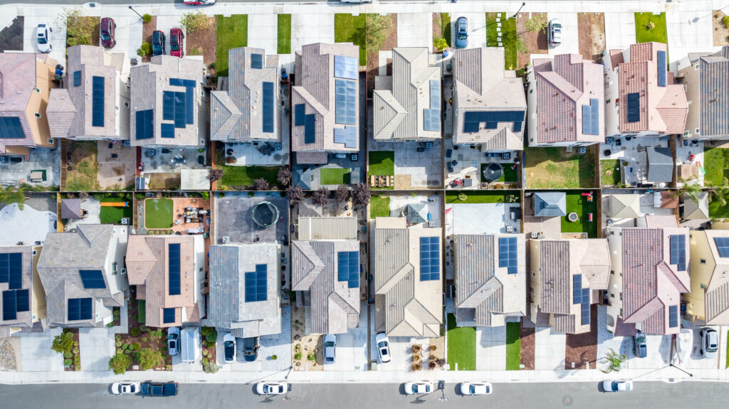 Top down view of a row of residential homes with solar panels on the roof