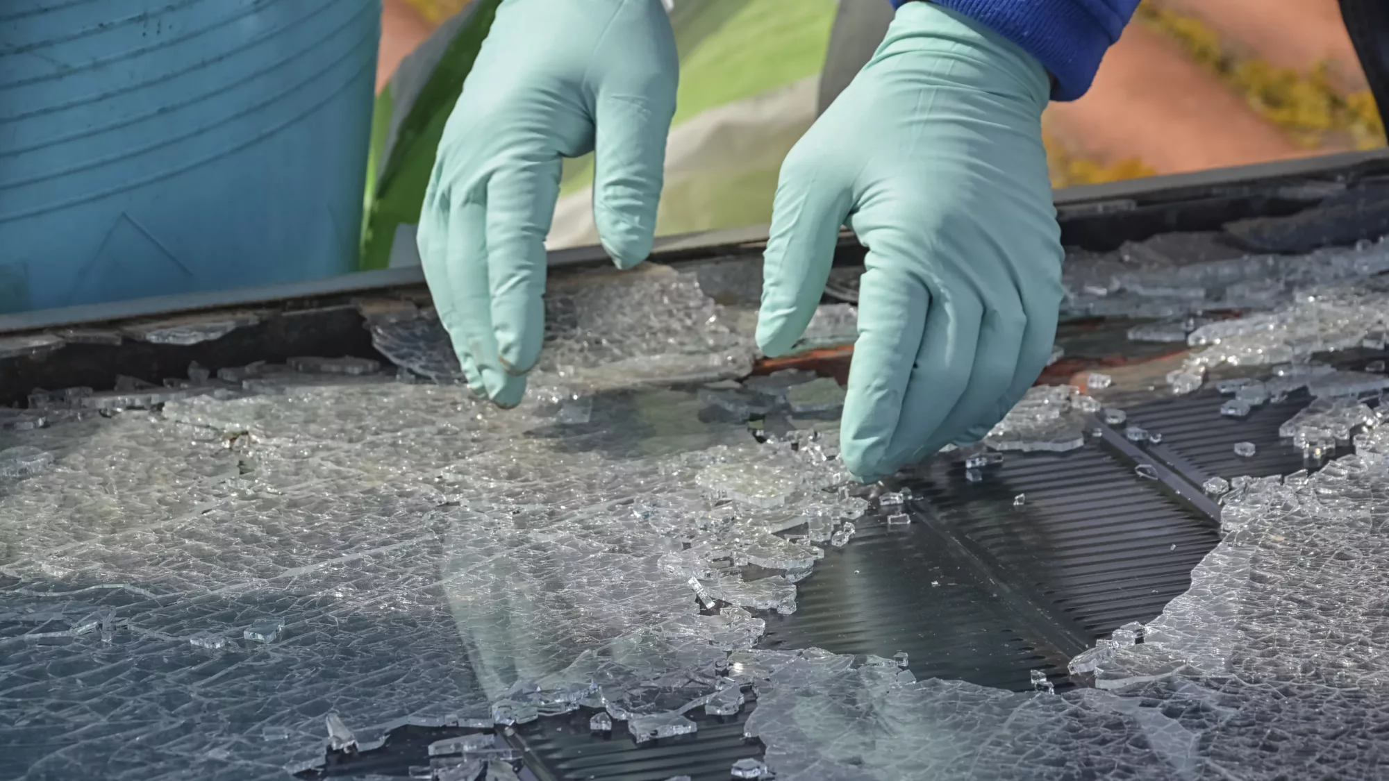 Technician collecting the glasses of a destroyed solar panel