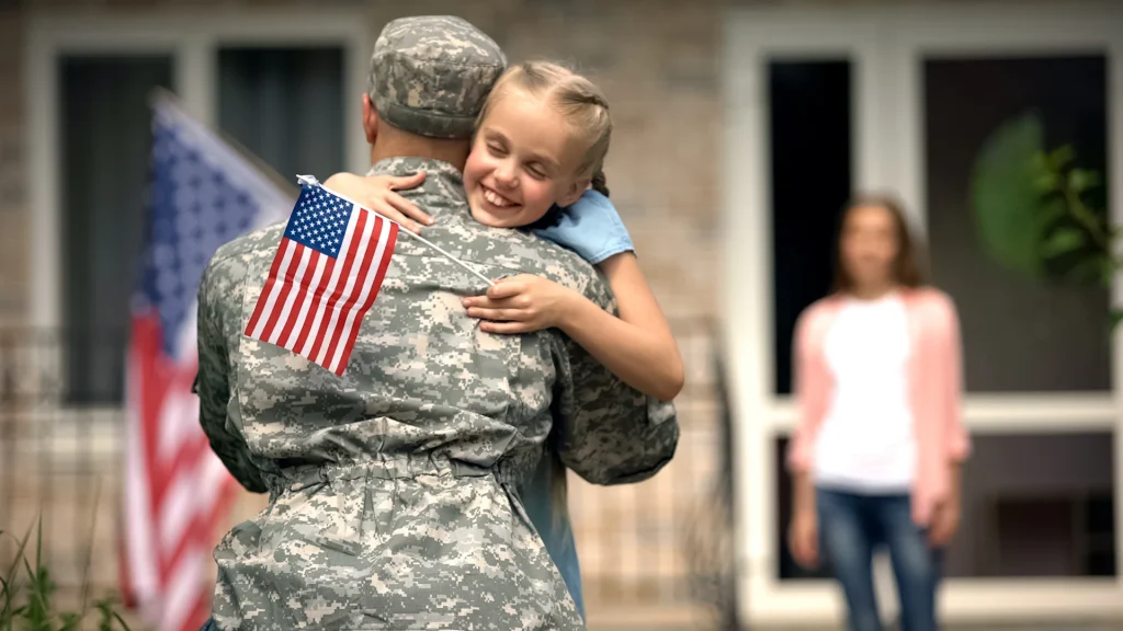 military man hugging his family